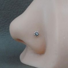 a close up view of a nose with a single diamond on it