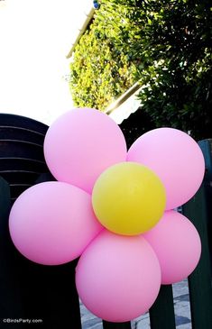 a bunch of balloons that are sitting on a fence