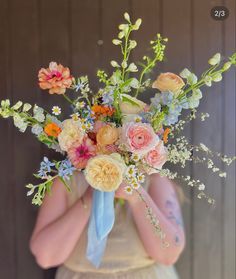 a woman holding a bouquet of flowers in her hands