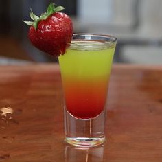 a strawberry sitting on top of a glass filled with liquid