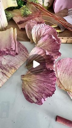 dried flowers on a cutting board next to a knife and some other things in the background