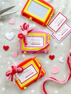 valentine's day gift tags and scissors on a white tablecloth with hearts around them