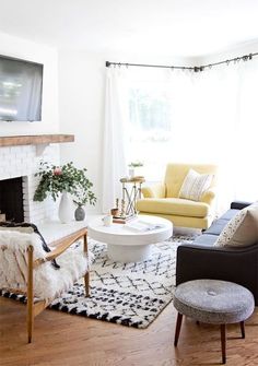 a living room filled with furniture and a fire place next to a wall mounted tv