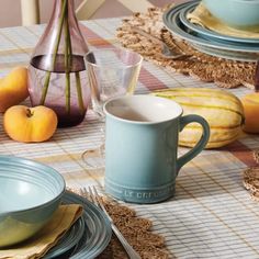 the table is set with plates, cups and bowls