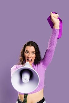 a woman holding a megaphone in her right hand and shouting into the air with one hand