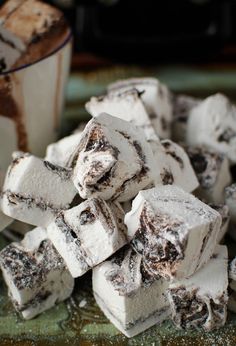 a pile of marshmallows sitting on top of a table next to a cup