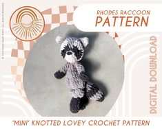 a crocheted raccoon stuffed animal sitting on top of a cement floor