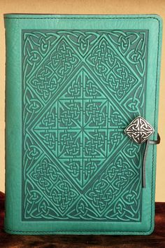 a green book with an intricate design on the cover