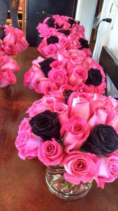 pink and black roses in a vase on a table