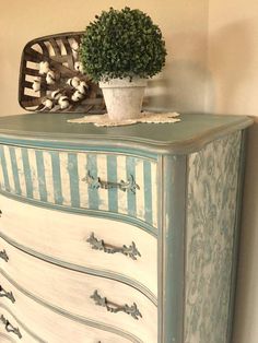 an old dresser has a potted plant sitting on it's top and bottom