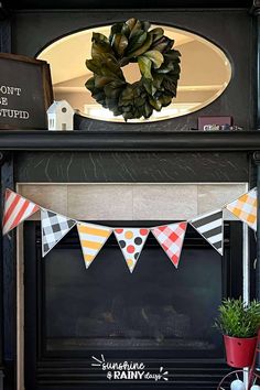 a mantel with a wreath on top of it and bunting flags hanging from the mantle