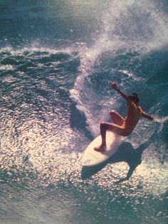 a man riding a wave on top of a white surfboard in the middle of the ocean