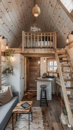 a living room filled with furniture next to a kitchen and lofted area on top of a wooden floor