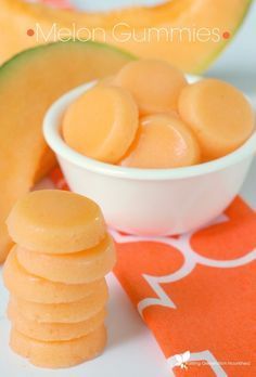 melon gummies are in a bowl next to an orange and white napkin with the word melon gummies on it