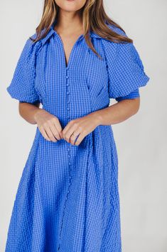 The Karsyn Midi Dress is a summertime must-have! This midi dress offers the comfortable shirt-dress silhouette we all love, but in an elevated design; its puffed short sleeves and darted bodice gives the Karsyn a flattering, feminine fit, while the beautiful textured fabric is lightweight and an eye-catching hue, perfect for all your summer jaunts. FIT: Runs true to size. MATERIAL: Shell: 100% Polyester; Lining: 100% Cotton. Hand wash cold; not not bleach, do not tumble dry. Iron low. GARMENT DE Summer Short Sleeve Shirt Dress For Brunch, Short Sleeve Shirt Dress For Summer Brunch, Short Sleeve Shirt Dress For Brunch, Chic Midi Dress With Gathered Short Sleeves, Blue Short Sleeve Midi Dress For Daywear, Summer Puff Sleeve Mini Dress, Blue Short Sleeve Dress For Spring, Summer Puff Sleeve Dress For Day Out, Summer Knee-length Short Sleeve Dress For Day Out