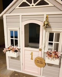 there is a doll house with flowers on the door