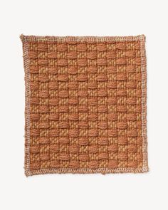 an orange and brown woven square rug on a white background