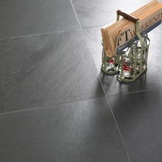 a wooden bench sitting on top of a tile floor next to a metal stand with an umbrella