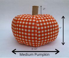 an orange and white checkered pumpkin is shown with the measurements for it's size