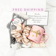 a pink coffee mug sitting in a box next to a stuffed animal and a free shipping sign