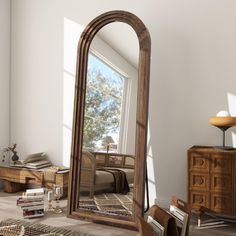 a large mirror sitting on top of a wooden floor next to a dresser and chair