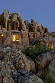 an outside view of some rocks with a window in the middle and a table on it