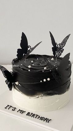 a black and white cake with butterflies on it