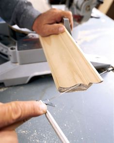 a person using a pair of pliers to cut wood planks on a table