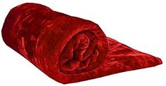 the red blanket is rolled up and ready to be used as a bedding material