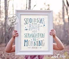 a woman holding up a framed poster with the words, second star to the right and straight on the morning