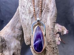 "Amethyst set in a Copper bezel with an Argentium silver Bail.  Amethyst is a teardrop shaped cabochon cut, natural gemstone. Pendant comes on a solid Copper, 20\" chain. STRUCTURE  * I Know *  CLEAN LINES AND ANGLES - Inventive - Powerful - Bold - Connective The Copper we use is 100% pure Copper - no alloys or additives.  This means the pendant is nickel-free because both the Copper and Silver are nickel free metals. Argentium Silver is a high quality silver with a silver content of 935.  It ha Lines And Angles, Amethyst Set, Argentium Silver, Copper Chain, Amethyst Necklace, Amethyst Pendant, Pure Copper, Gemstone Pendant, Clean Lines