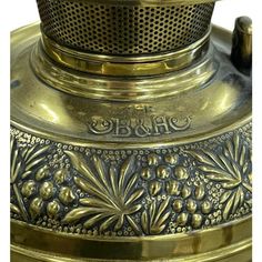 an antique brass plated tea kettle with grapes on it