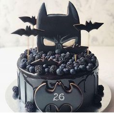 a batman themed cake with berries and blackberries