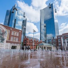 there is a fountain in front of the buildings