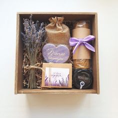 an open box containing lavenders, honey, soap and other personal care items with a purple ribbon