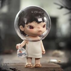 a small figurine is holding a glass ball