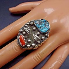 "VINTAGE NAVAJO RING DESCRIPTION: This impressive ring features natural specimens of Morenci turquoise and old red Mediterranean coral. The gemstones are secure in sawtooth bezel, on a foundation of heavy gauge vintage sterling silver. Applied raindrops and leaves embellish the face of the ring. This ring will be a treasured addition to your collection of fine vintage Native American jewelry. MEASUREMENTS: Ring face measures 1 1/4\" x 7/8\" Turquoise Cabochon measures 13mm x 11mm RING SIZE: 11 1 Southwestern Style Red Turquoise Ring, Jewelry Measurements, Navajo Ring, Morenci Turquoise, Vintage Native American Jewelry, Navajo Rings, Vintage Navajo, Coral Turquoise, American Jewelry