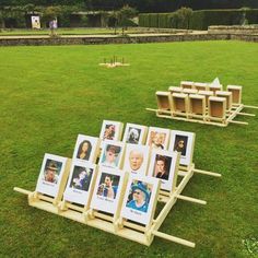 several wooden frames with pictures on them sitting in the middle of a field next to benches