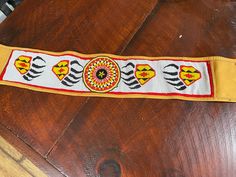 a close up of a wooden table with a ribbon on it that has designs on it