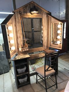 an old vanity with lights on it and a chair in front of the mirror that is lit up