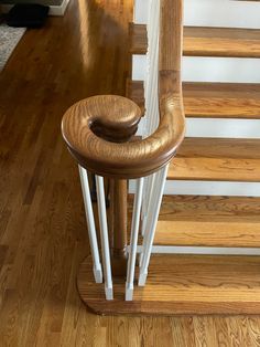 a wooden staircase with white handrails and wood flooring