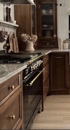 a kitchen with wooden cabinets and an oven in the center, along with marble counter tops