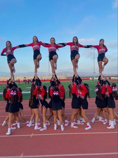 a group of cheerleaders standing on top of each other in the middle of a track