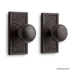 two black door knobs on a white wall