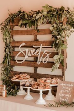 an assortment of desserts on display in front of a wooden sign