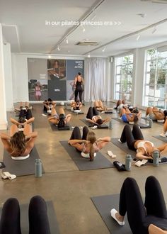 a group of people doing yoga in a large room