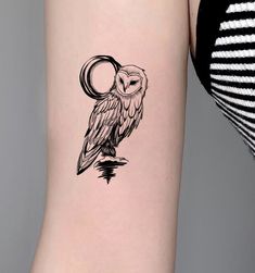 an owl tattoo on the back of a woman's leg