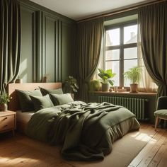 a bedroom with green walls and wooden flooring, large bed covered in olive green linens