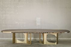 a wooden table sitting in front of a wall with a circular design on the top