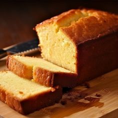 a loaf of pound cake sitting on top of a cutting board next to a knife